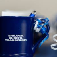 close-up of blue give-away cups that read "ENGAGE ENRICH TRANSFORM"